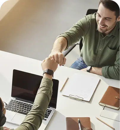 Coworkers fist-bump over desk