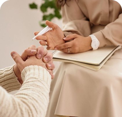 Two people meeting zoomed in on their hands as they sit across from each other.