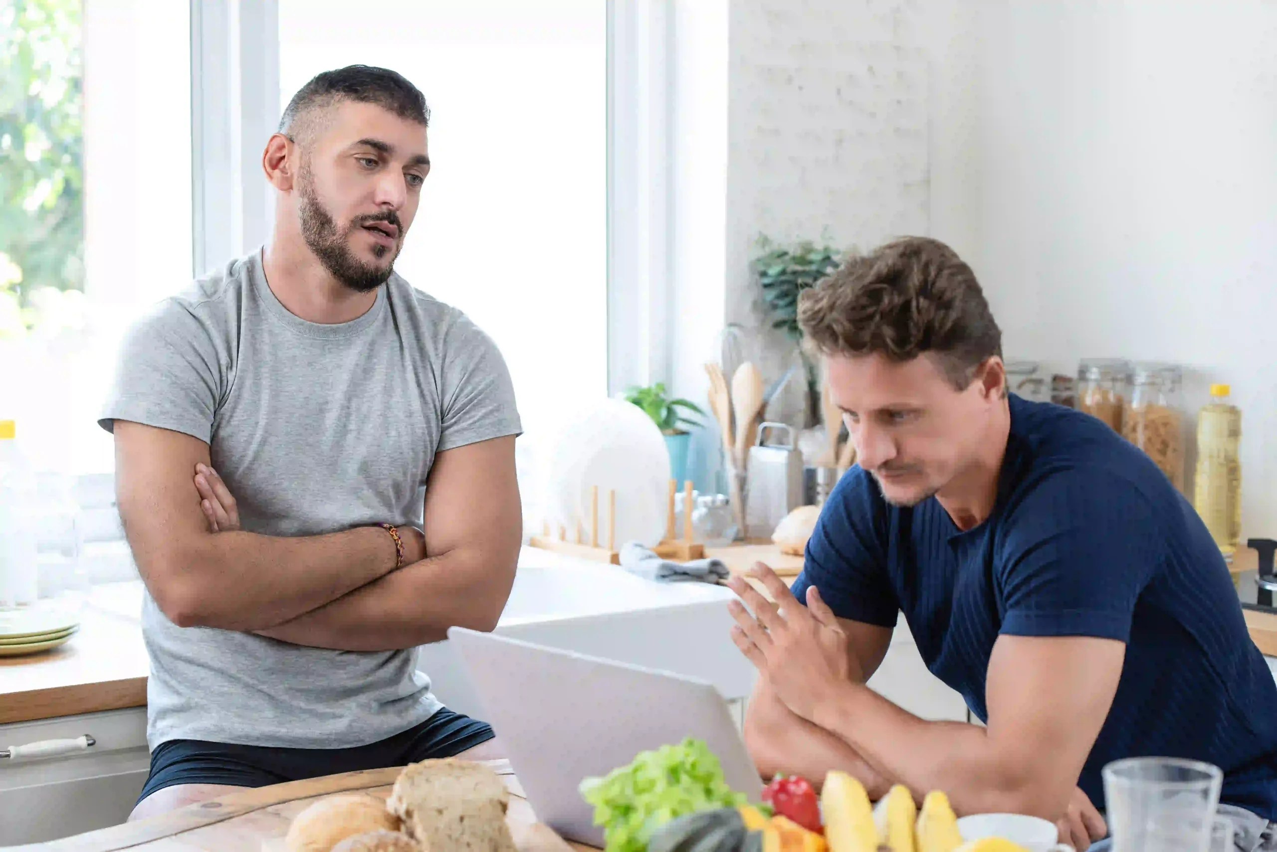 Two men in kitchen discussing options