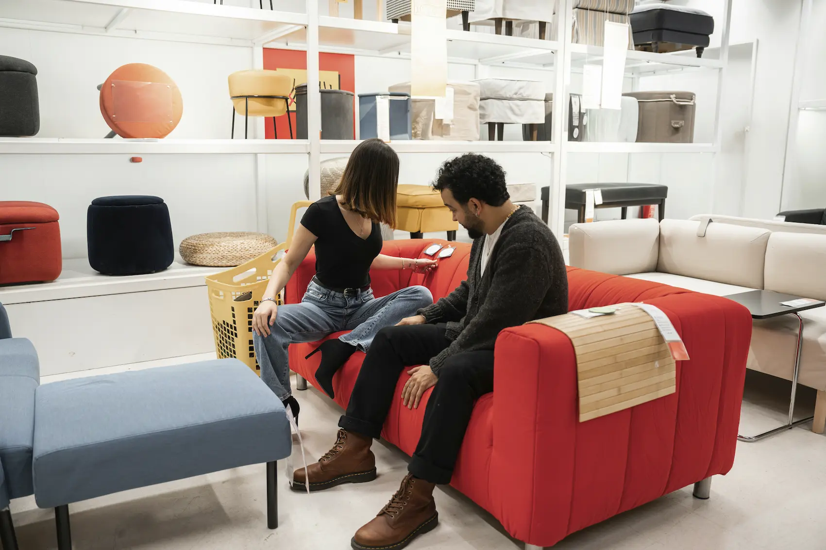 Two people testing a couch in a furniture store