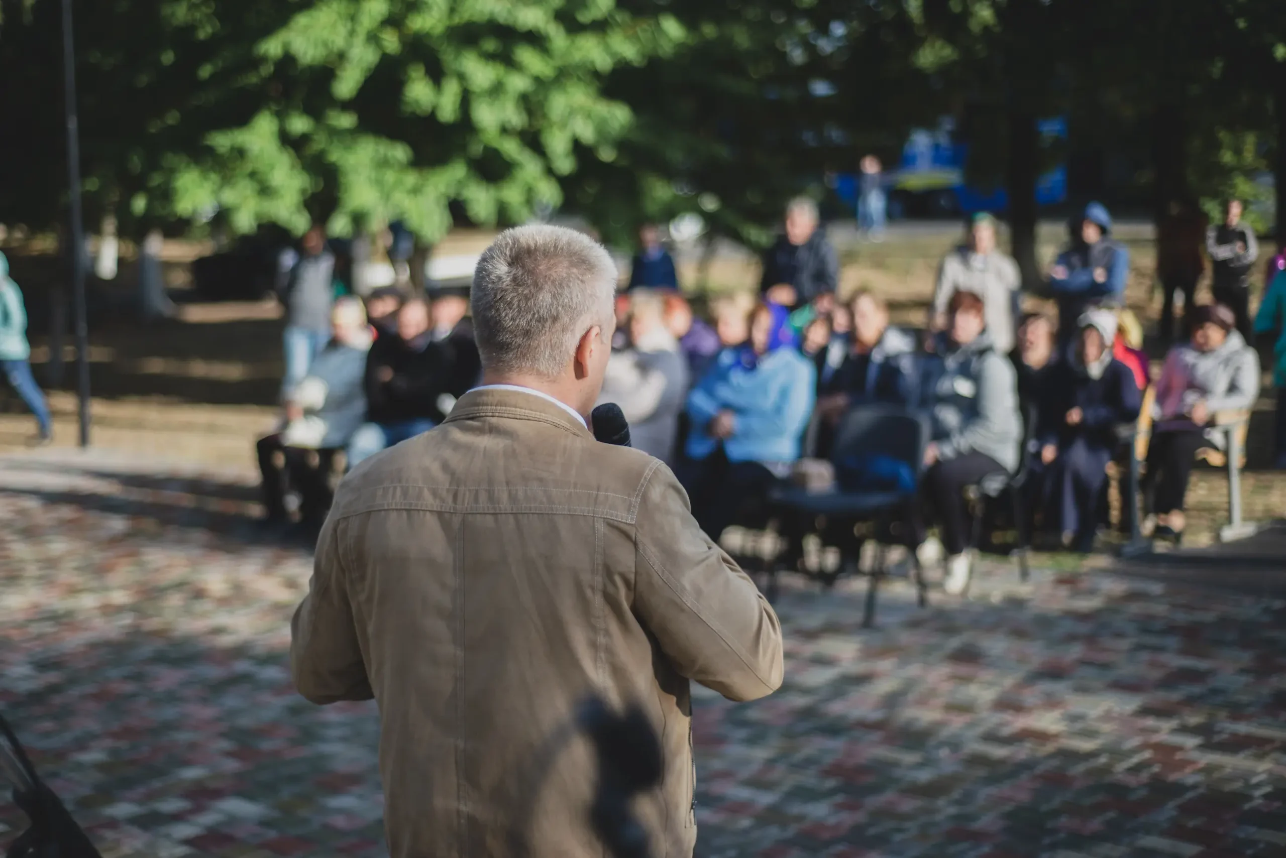 Person speaking to an audience in a park